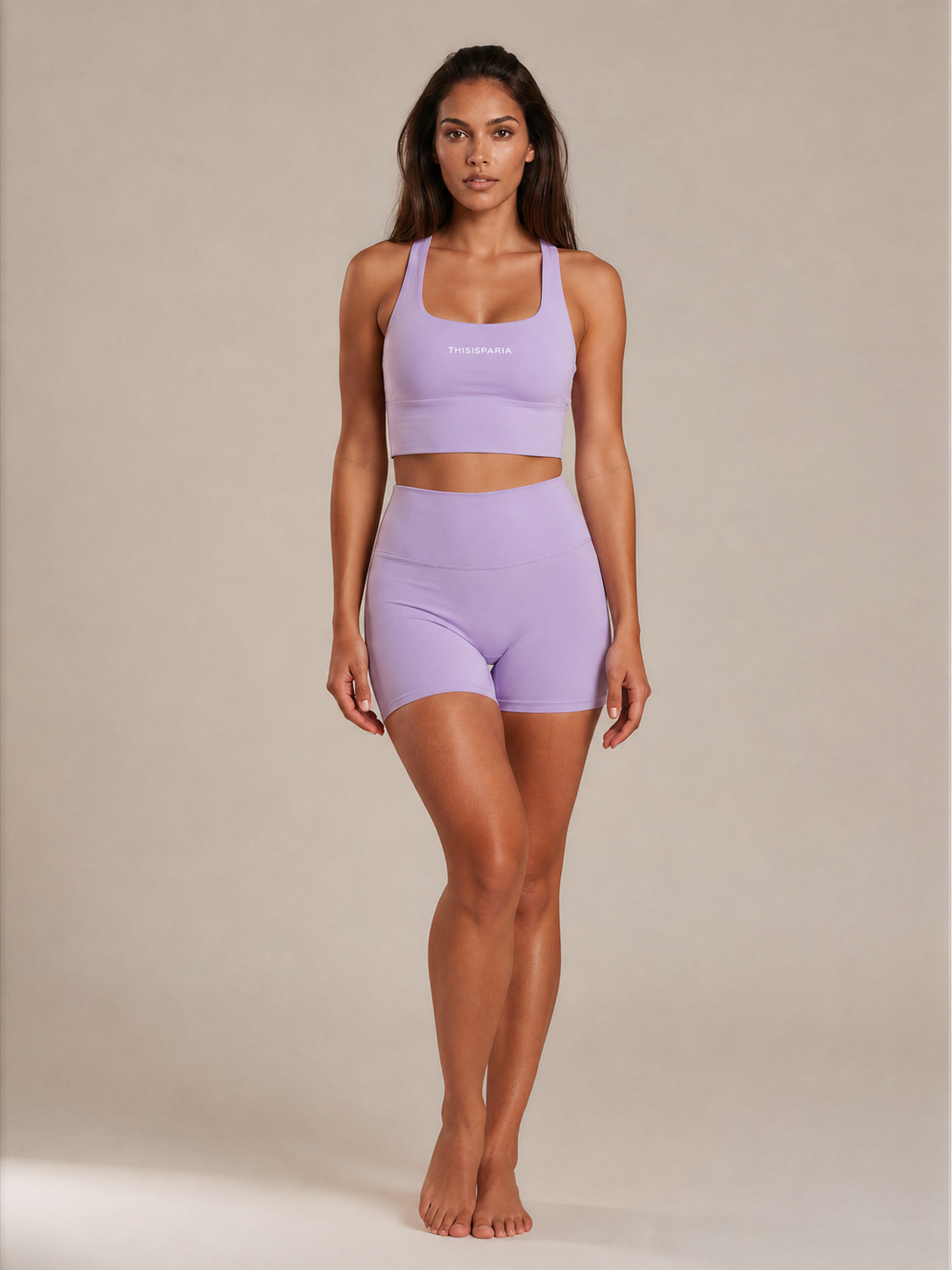 Model wearing a lilac activewear set with a cropped sports top and high-waisted fitted shorts, shown from the front.