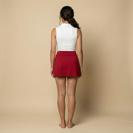 Back view of women’s red and white tennis set with sleeveless performance top and built-in shorts skirt – Scarlet Court Set UK